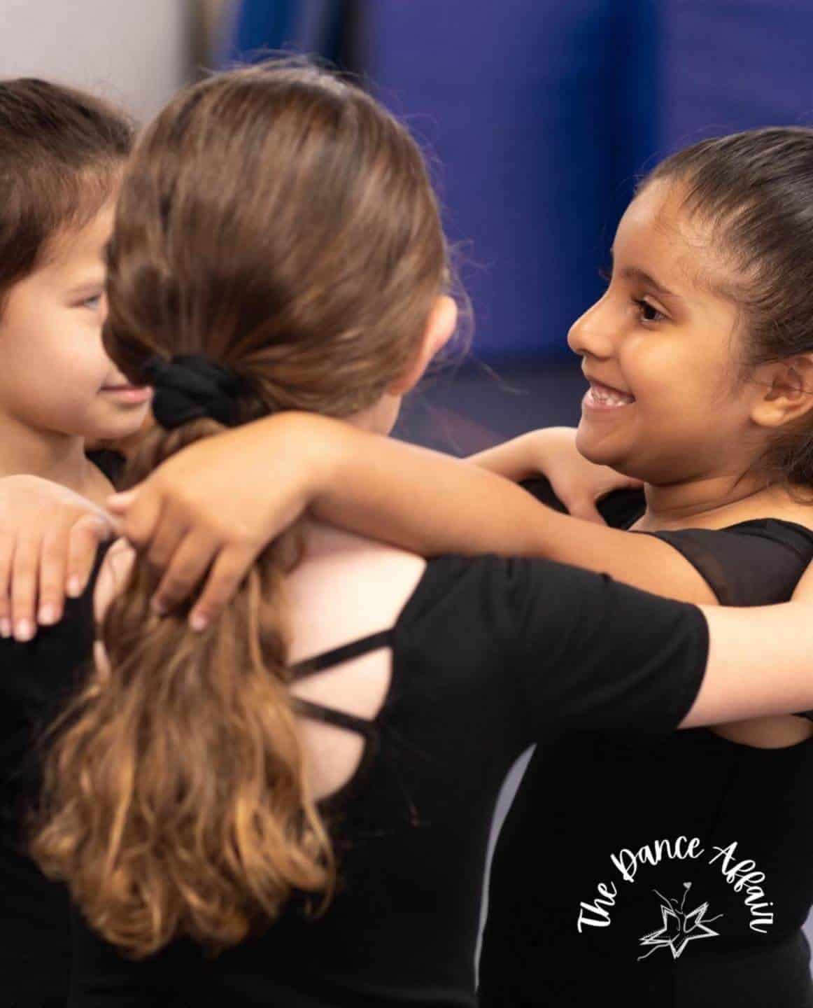 Dancers hugging inside studio Dancers hugging inside studio